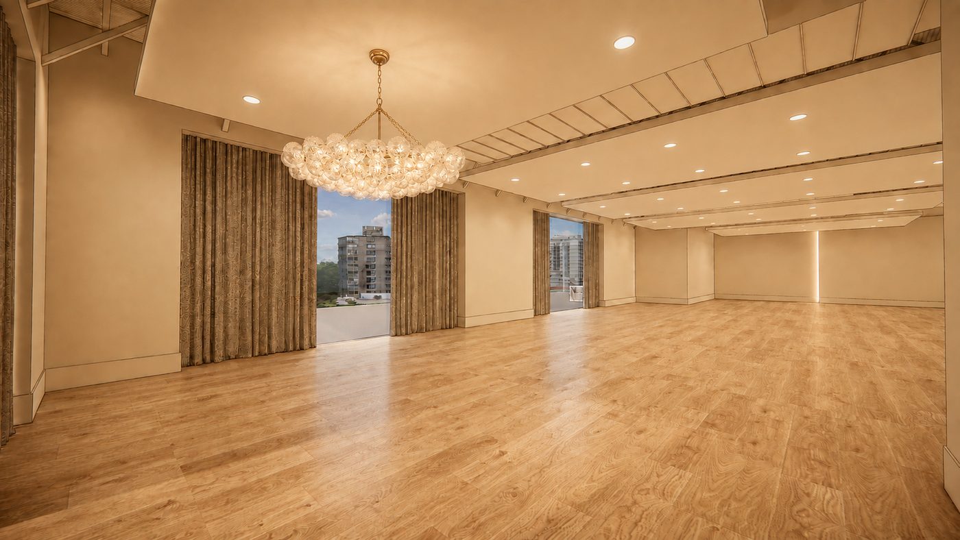 The main event floor under a large bubble chandelier, light oak floors, and drapes drawn back from tall windows